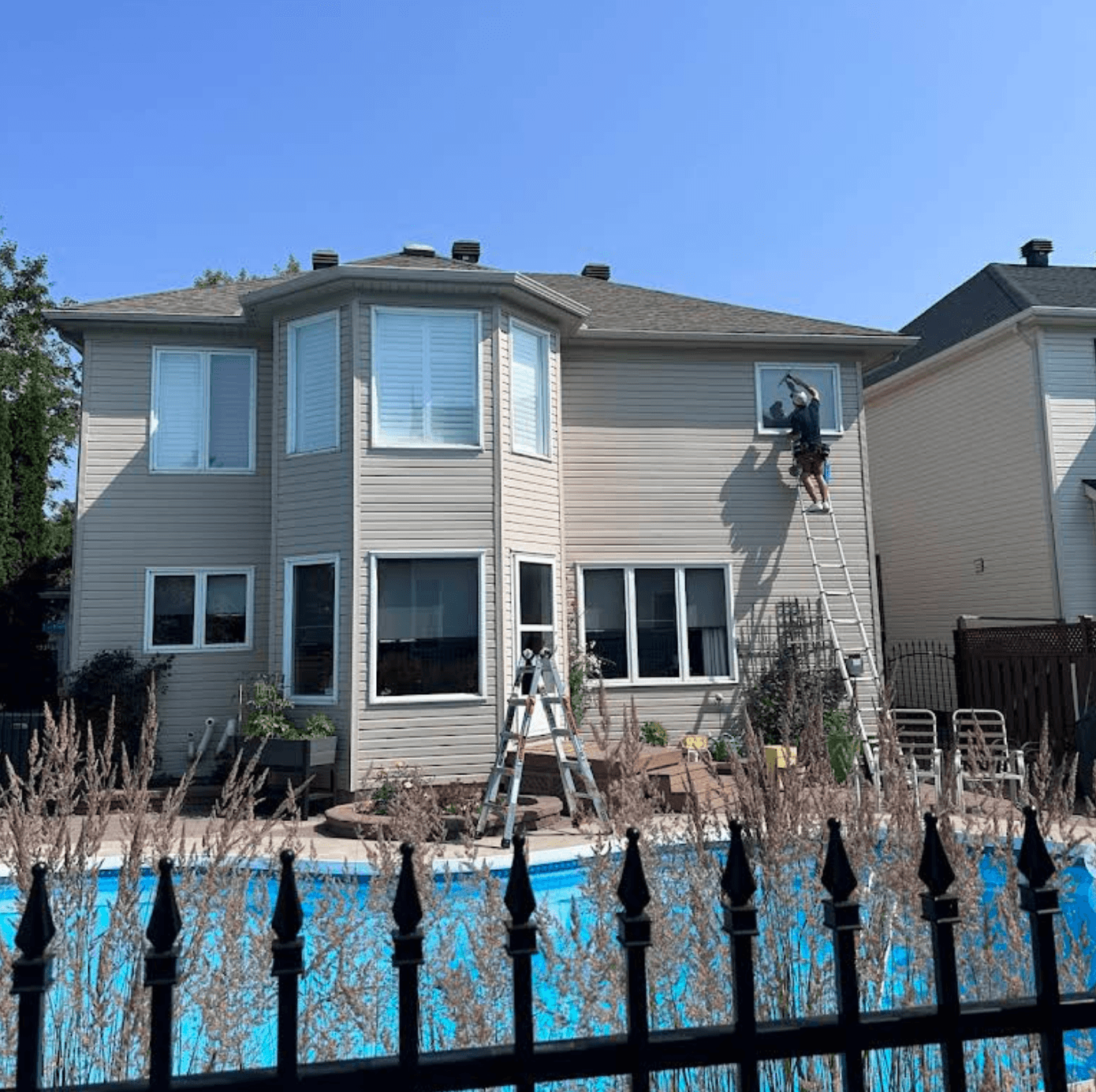Luxview technician cleaning second-storey windows on an Ottawa home